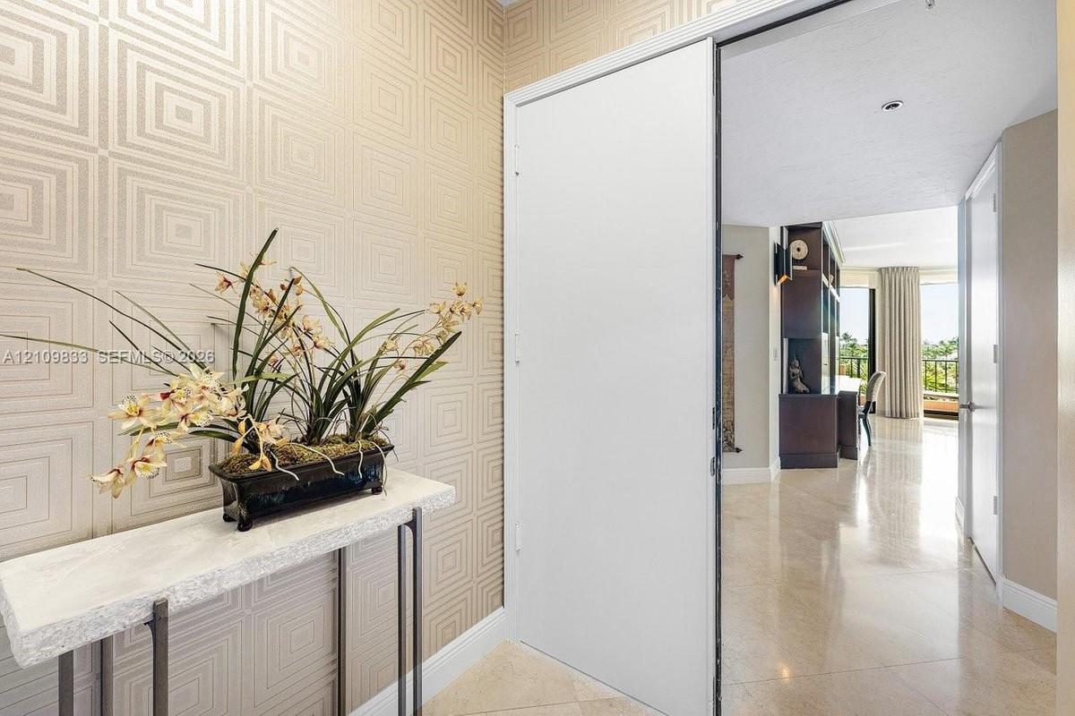 Entryway featuring geometric patterned wall coverings, stone-finish flooring, and a sliding door