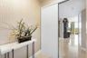 Entryway featuring geometric patterned wall coverings, stone-finish flooring, and a sliding door