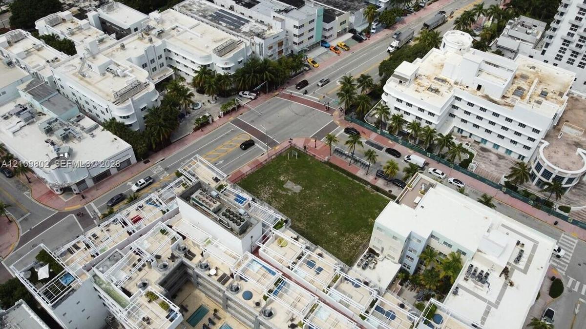 Corner lot featuring open green space situated at a street intersection within an urban district