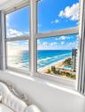 Large multi-pane windows featuring ocean and coastline scenery