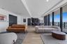Open-concept living space featuring wood-finish flooring, floor-to-ceiling glass wall, recessed lighting, and kitchen cabinetry with integrated applia