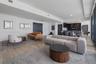 Open-concept floor plan featuring wood-finish flooring, high ceilings, recessed lighting, and kitchen cabinetry with integrated appliances
