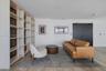 Custom built-in floor-to-ceiling shelving with integrated vertical lighting, wood-finish flooring, and double-door entry