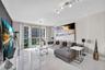 Large-format tile flooring, floor-to-ceiling glass sliding doors, private balcony, and multi-directional track lighting