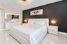 Polished tile flooring, contrast charcoal accent wall, and geometric branch-style chandelier