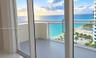 Private balcony featuring glass railings and direct oceanfront scenery