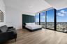 Floor-to-ceiling windows, wood-finish flooring, and built-in upholstered headboard wall paneling
