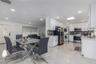 Kitchen featuring white shaker-style cabinetry, stainless steel appliances, stacked laundry unit, polished tile flooring, and recessed lighting