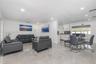 Open-concept interior featuring large-format polished tile flooring, recessed lighting, crown molding, and white shaker-style cabinetry