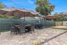 Outdoor patio featuring multi-tonal concrete pavers, tiered levels, and a privacy screen perimeter