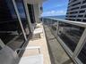 Covered balcony featuring stone flooring and a glass-paneled railing