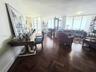 Herringbone-patterned wood-finish flooring, floor-to-ceiling windows, and crown molding