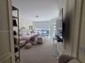 Wall paneling detailing, wall-to-wall carpeting, and floor-to-ceiling windows with integrated roller shades