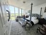 Floor-to-ceiling windows, built-in cabinetry with integrated shelving, and carpeted flooring