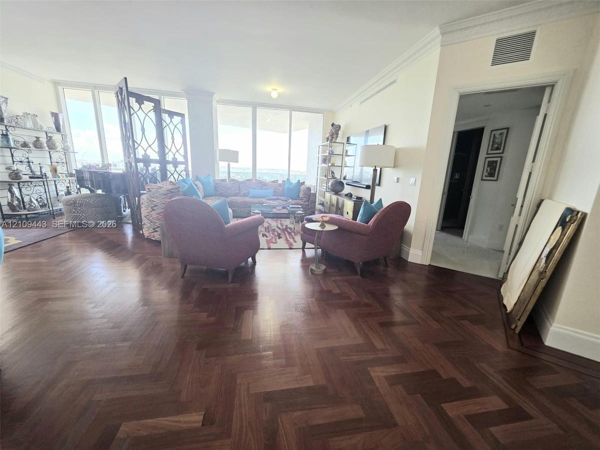 Herringbone-patterned wood-finish flooring, floor-to-ceiling windows, and crown molding