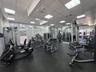 Fitness center featuring recessed square lighting, wall-to-wall mirrors, rubberized flooring, and expansive windows