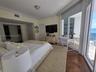 Herringbone-patterned wood-finish flooring, floor-to-ceiling glass sliding doors, crown molding, and recessed lighting