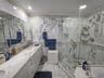 Bathroom featuring full-height stone wall tiling, a double vanity with stone countertop, recessed lighting, and a walk-in glass-enclosed shower with g
