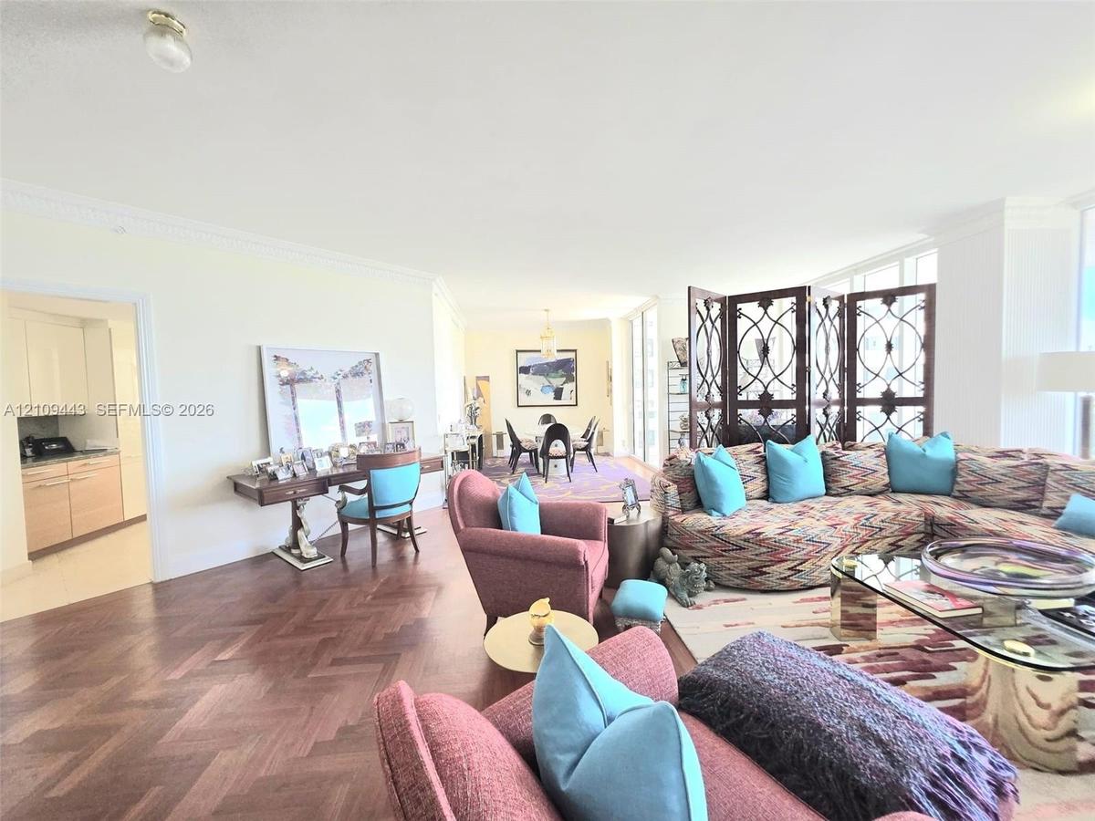 Herringbone-patterned wood-finish flooring, crown molding, floor-to-ceiling windows, and recessed ceiling lighting