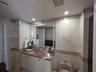 Vanity featuring a stone countertop with an integrated basin, neutral tile wall cladding, and decorative diamond-patterned tile inlay