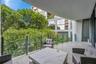 Covered balcony featuring wood-finish flooring and a transparent glass panel railing