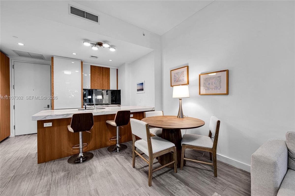 Kitchen featuring a stone-finish countertop, wood-finish cabinetry, built-in light fixtures, and wood-finish flooring throughout the space