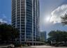 High-rise building exterior featuring a curved facade, floor-to-ceiling glass windows, and wrap-around balconies