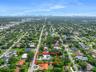 Aerial perspective of a property featuring a swimming pool, expansive lot, and mature landscaping