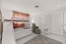 Neutral interior featuring large-format tile flooring, recessed ceiling lighting, and double closets with white louvered doors