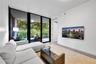 Floor-to-ceiling glass sliding doors, wood-finish flooring, and a private balcony with glass railing