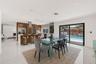 Kitchen featuring wood-finish cabinetry, a large waterfall-edge island, built-in stainless steel appliances, and recessed lighting