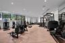 Fitness center featuring wood-finish flooring, extensive floor-to-ceiling mirrored walls, horizontal window banks, and recessed LED ceiling lighting