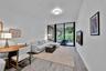 Open-concept interior featuring wood-finish flooring, a flush-mount circular ceiling fixture, and floor-to-ceiling sliding glass doors leading to an e