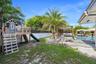 Backyard featuring a swimming pool, concrete patio, wooden pergola, and built-in elevated play structure