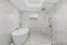 Freestanding soaking tub featuring a wall-mounted gold-tone faucet, accompanied by a walk-in shower with a glass panel, gold-tone rainfall shower head