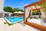 Backyard featuring a rectangular swimming pool, concrete patio surfacing, custom wood-framed pergola, and perimeter privacy fencing