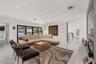 Open-concept living space featuring high-gloss tile flooring, recessed lighting, and expansive black-framed multi-panel sliding glass doors