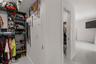 Walk-in closet featuring floor-to-ceiling built-in shelving, hanging rods, and large-format tile flooring