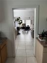 Wide entryway featuring ceramic tile flooring, light-toned wood cabinetry, and stone-finish countertops