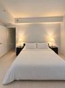 Neutral interior featuring light-toned wood-finish flooring, smooth ceilings, and minimalist recessed interior door