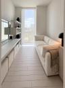 Floor-to-ceiling window, built-in shelving unit, and tile flooring