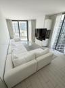Floor-to-ceiling glass panel walls, custom built-in white cabinetry, and light-toned tile flooring throughout