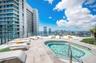 Rooftop terrace featuring an in-ground pool, stone-tile decking, and a glass-panel perimeter railing