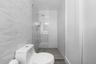 Walk-in shower featuring textured geometric wall tile, a frameless glass enclosure, a rainfall showerhead, and a built-in recessed niche