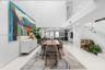 Double-height ceilings, polished tile flooring, floating staircase with glass railings, recessed lighting, and expansive wall space