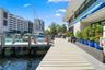 Waterfront property featuring a private composite dock, direct water access, and exterior stairs with integrated landscaping