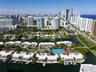 Aerial perspective featuring waterfront residential property with private boat slips, direct canal access, and communal tennis courts