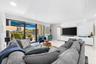 Hallway featuring polished tile flooring, recessed lighting, and a bathroom equipped with a floating vanity, light-toned wood-finish cabinetry, and a 