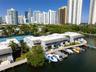 Waterfront property featuring a private deep-water dock, integrated boat slips, paved pathways, and tennis courts