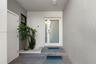 Entryway featuring a white door with a frosted glass panel, recessed ceiling lighting, textured wall finish, grey tiled flooring, and a built-in stone